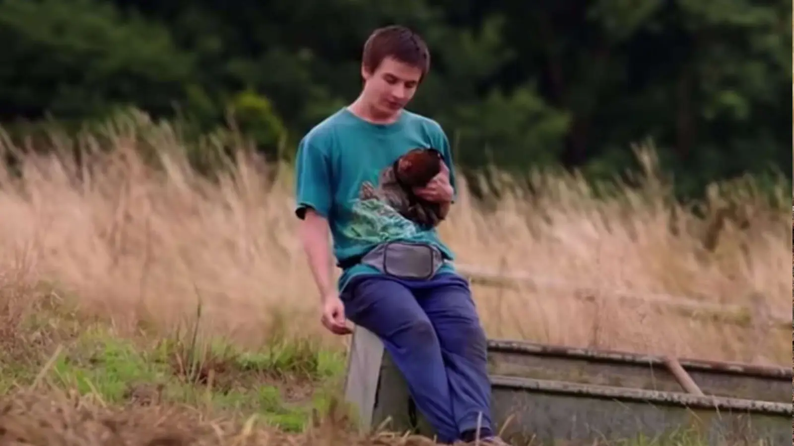 young man holding a chicken