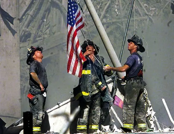 firefighters raising an American flag