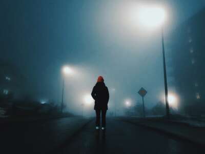 woman walking in a foggy street