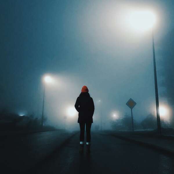 woman walking in a foggy street
