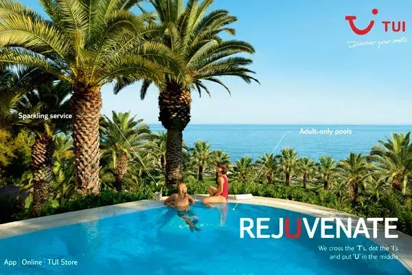 couple relax in a swimming pool surrounded by palm trees