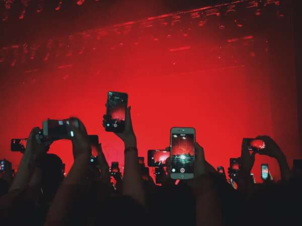 concert goers taking pictures with their phones