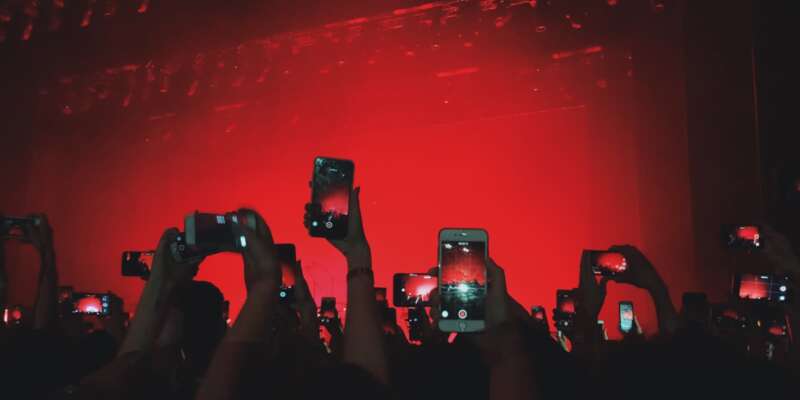 concert goers taking pictures with their phones