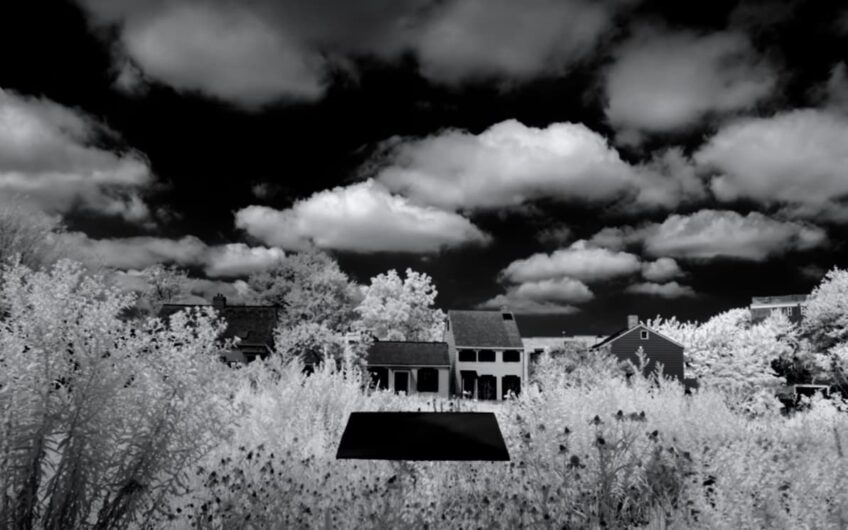 black monolith floating in front of houses