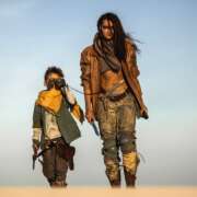Post apocalyptic woman and boy heroically walking