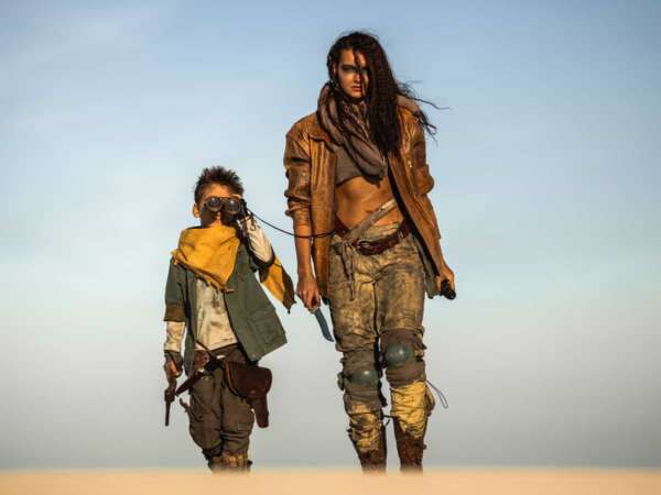 Post apocalyptic woman and boy heroically walking