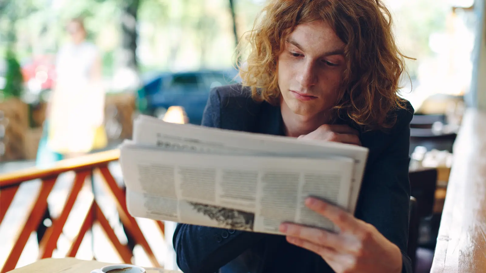 young man reading the Guardian newspaper