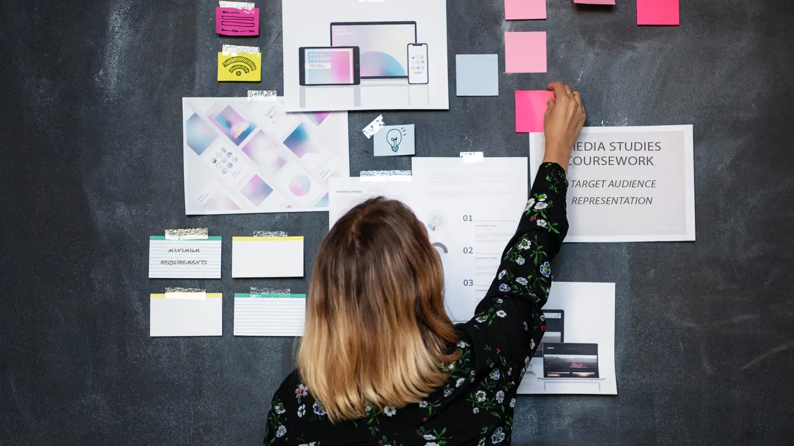 student planning her coursework on a blackboard