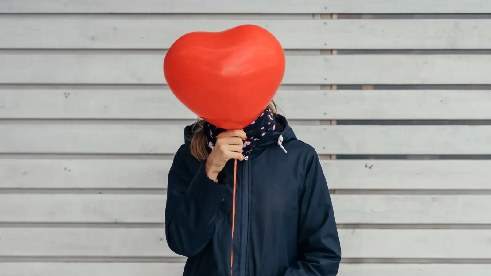 lady with heart balloon in front of her face