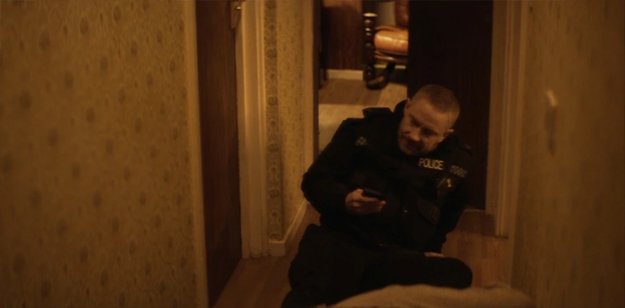 police officer on the ground looking at his phone