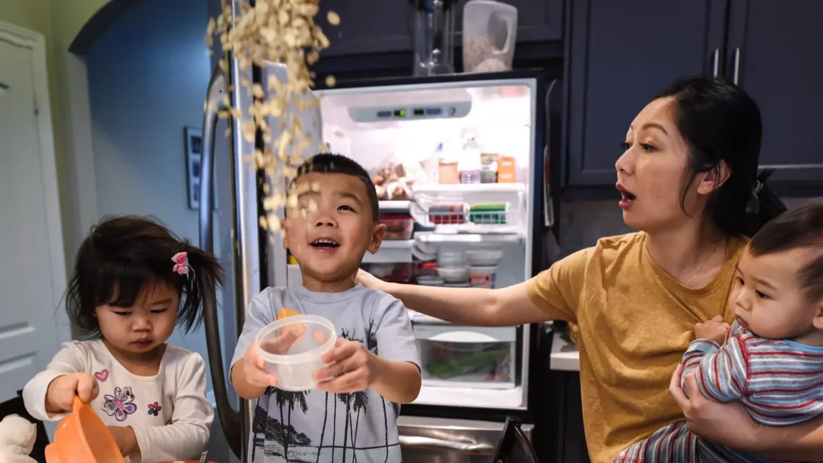 mother looking after her children in the messy kitchen
